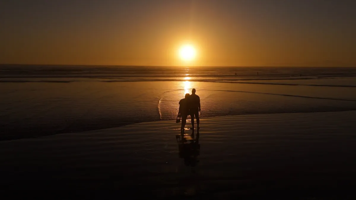 A couple on the beach at sunset