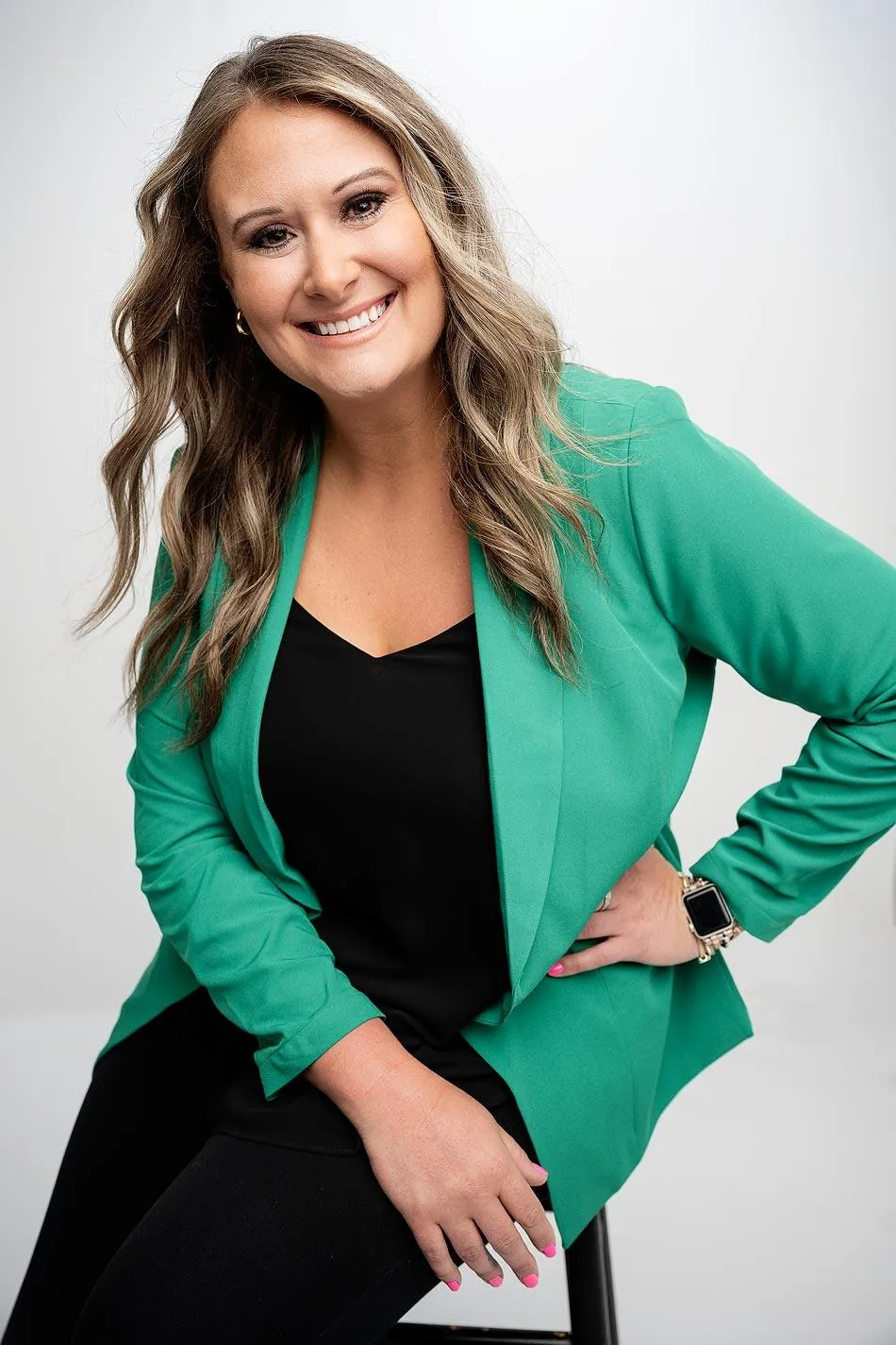 Business woman in a branding session, smiling confidently in a professional studio setting.