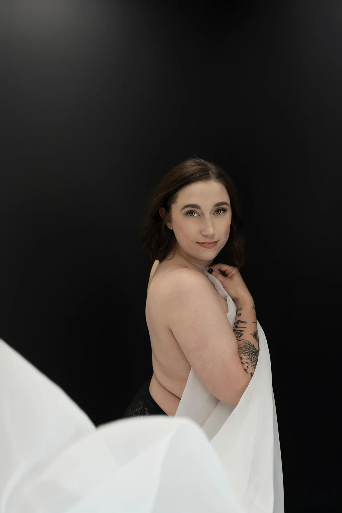Woman in a boudoir session, celebrating her body and strength through a powerful, intimate photo