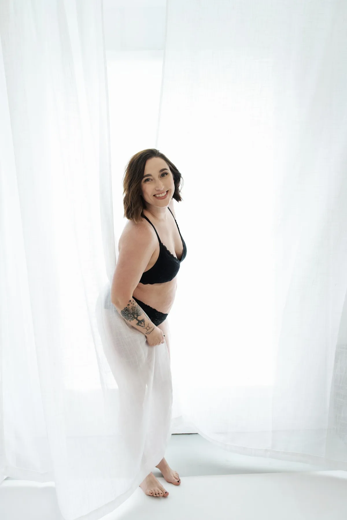 Woman in a boudoir session, celebrating her body and strength through a powerful, intimate photo