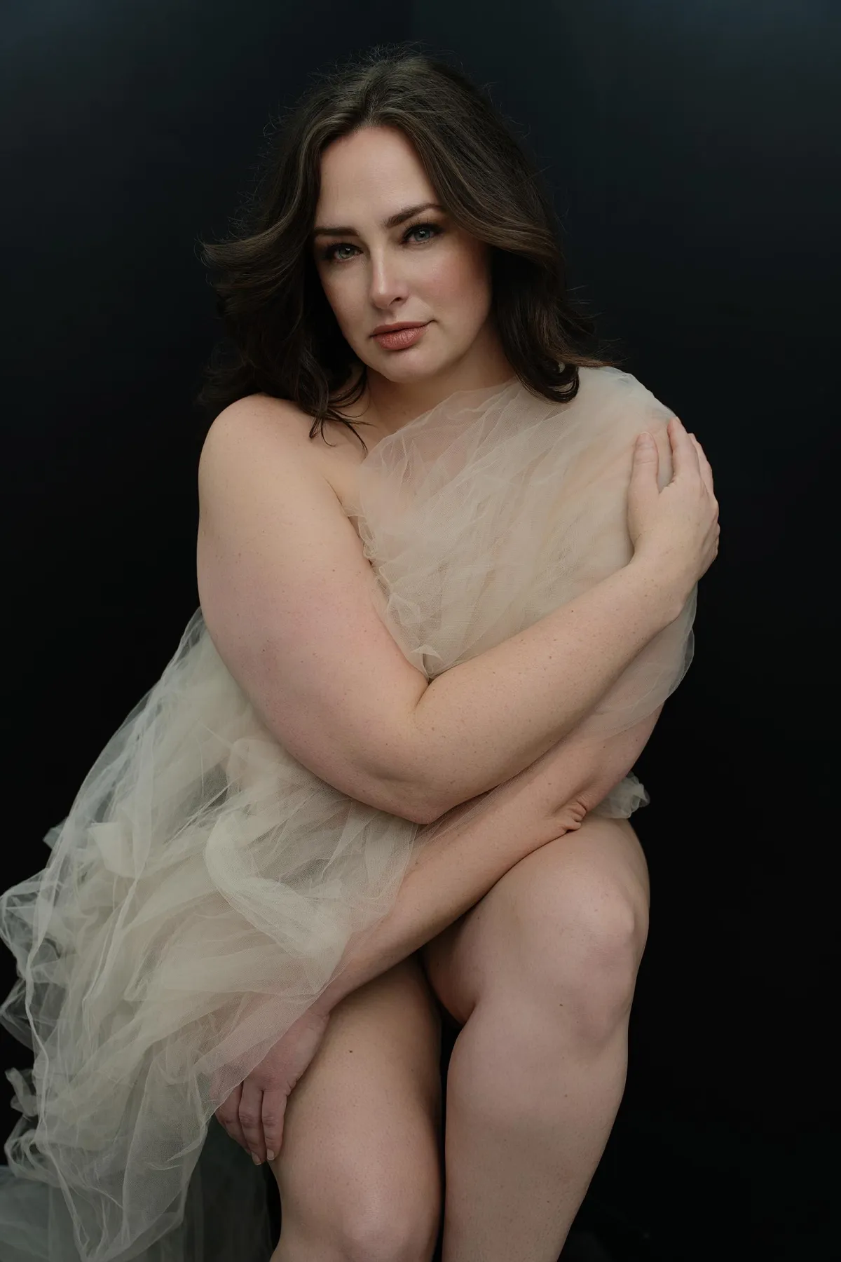Empowered boudoir photo session capturing a woman embracing body positivity and self-love