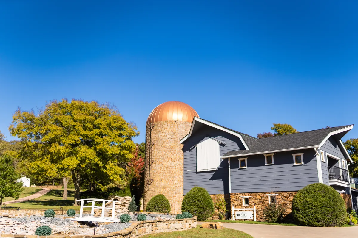 The Silo Event Center wedding venue exterior in Tulsa, Oklahoma with fall foliage, where couples compare fall wedding dates