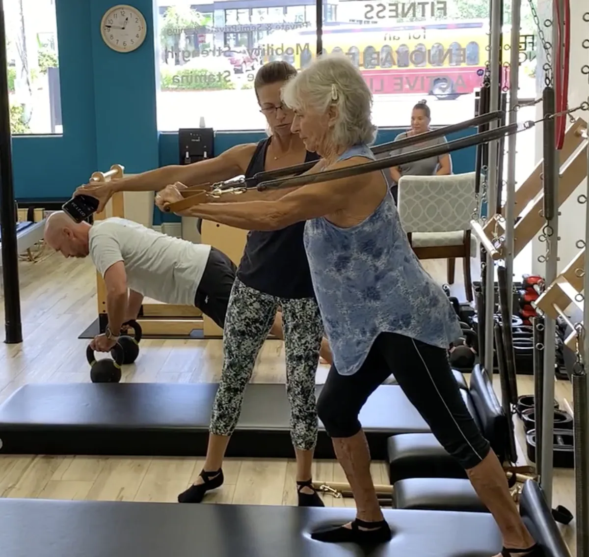 Senior woman strength training with Personal Trainer using the Pilates tower in St. Petersburg, Florida