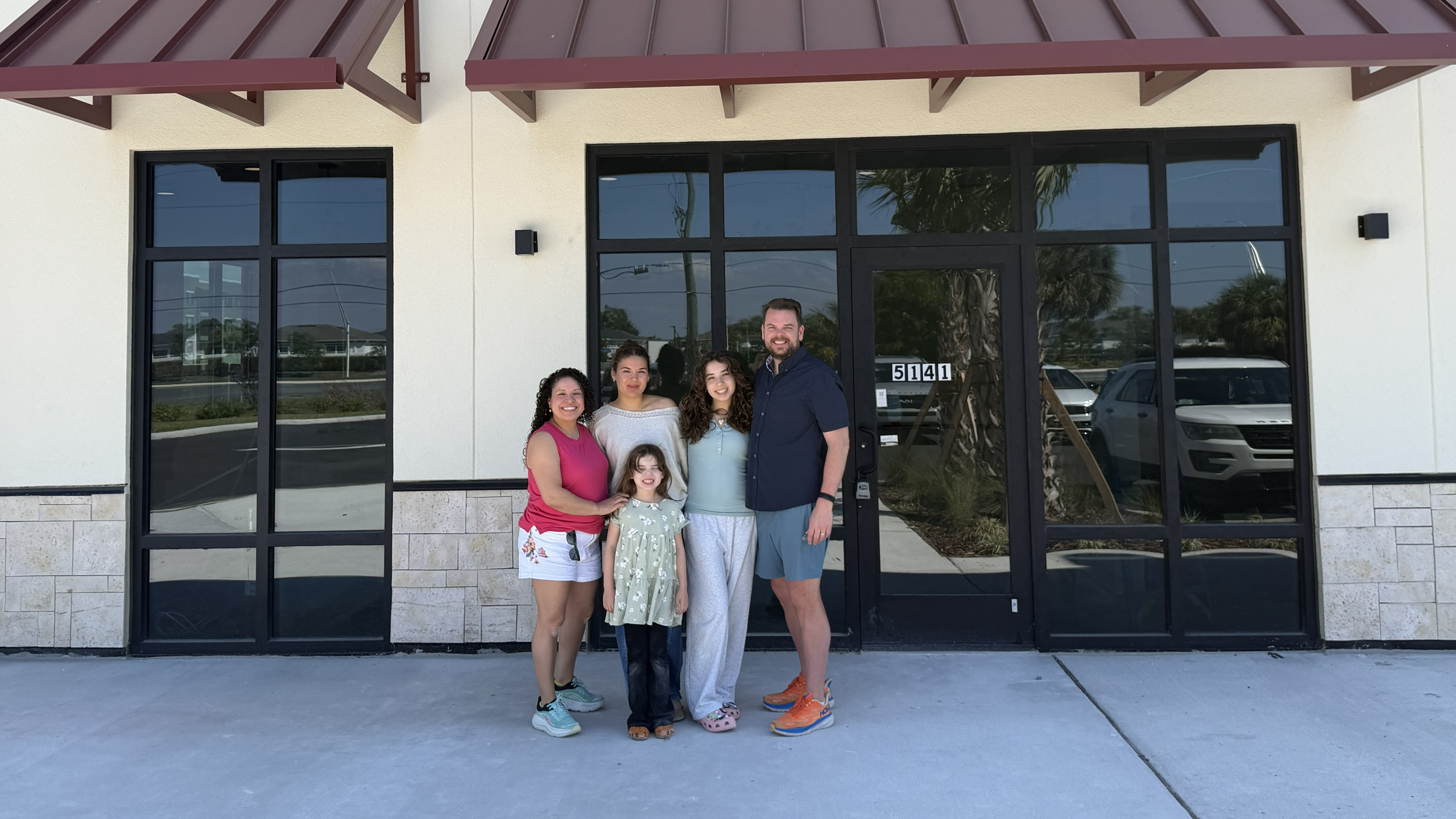 Photo of Dr. Joshua Belof and his family, standing outside of Love Dental in Palmetto, FL