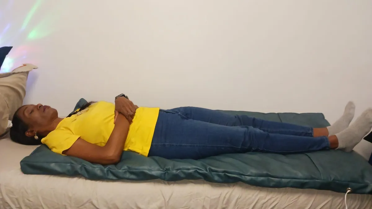 Person lying on a vibro-acoustic mattress or healing