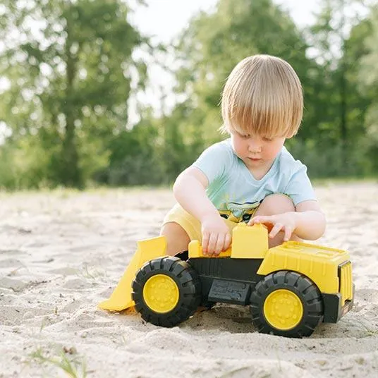 boy playing with dump truck in sand