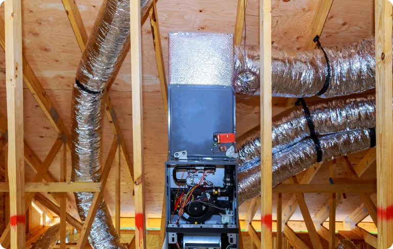Heating system installation in attic with ducts and wooden beams, showcasing HVAC equipment for efficient home warmth.