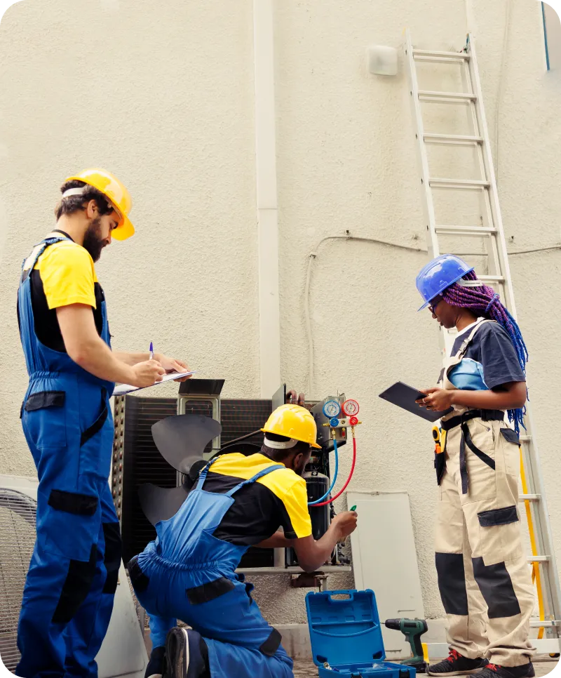 HVAC technicians inspecting and servicing air conditioning unit, emphasizing professional maintenance and climate control solutions for property management.