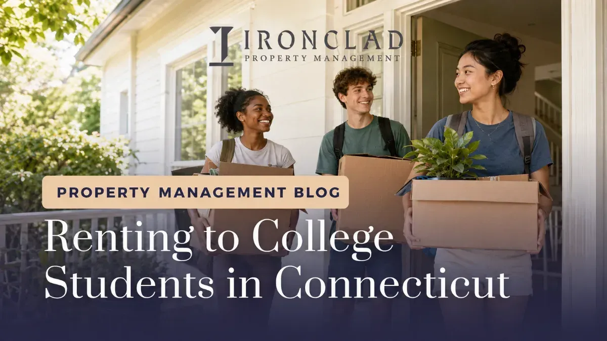 Three smiling college students, two women and one man, carrying moving boxes and a plant out of a house, representing new tenants for a Connecticut rental property managed by Ironclad Property Management.