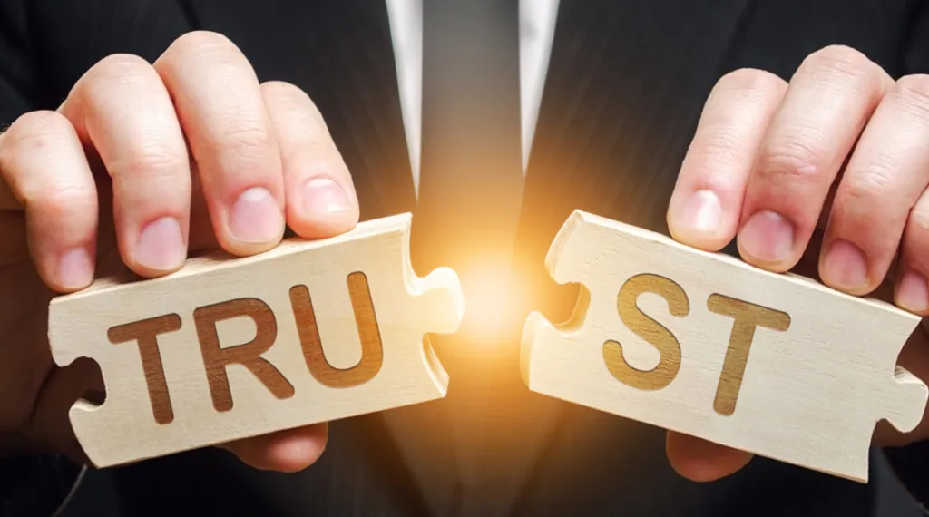 trust spelled with wooden letter blocks on a table