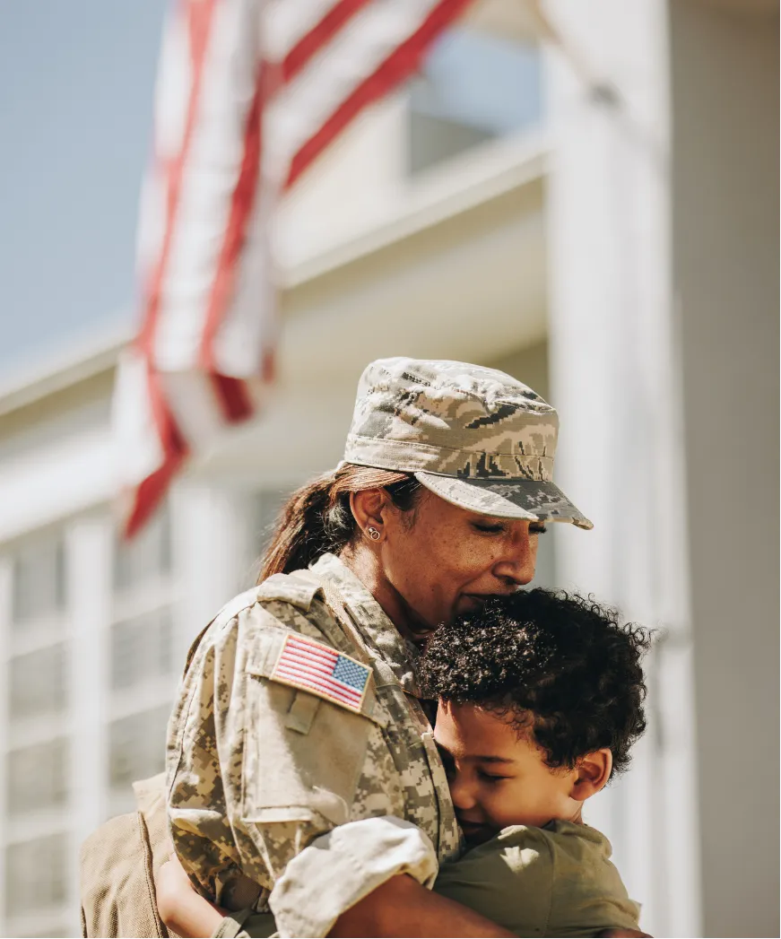 U.S. veteran hugging child at homecoming, symbolizing family, service, and VA home loan support.