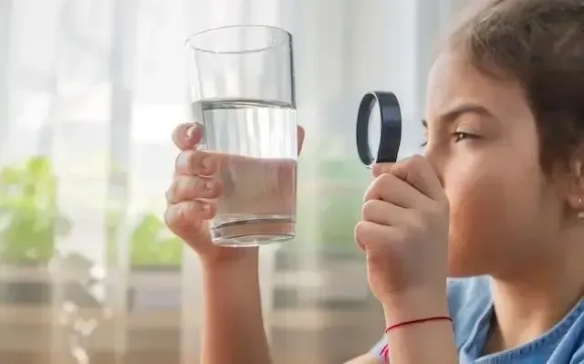 child looking at water glass