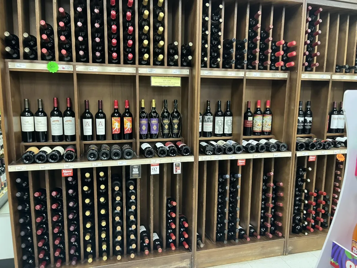 Warm interior shot of the store's tasting shelf with varied bottle shapes and inviting aisle.
