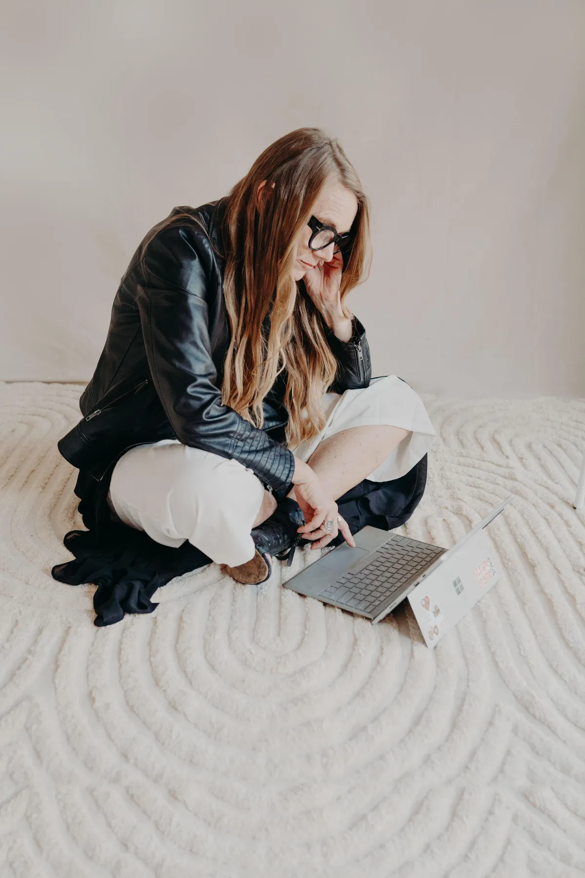 Woman sitting on floor with computer. Looking disconnected.