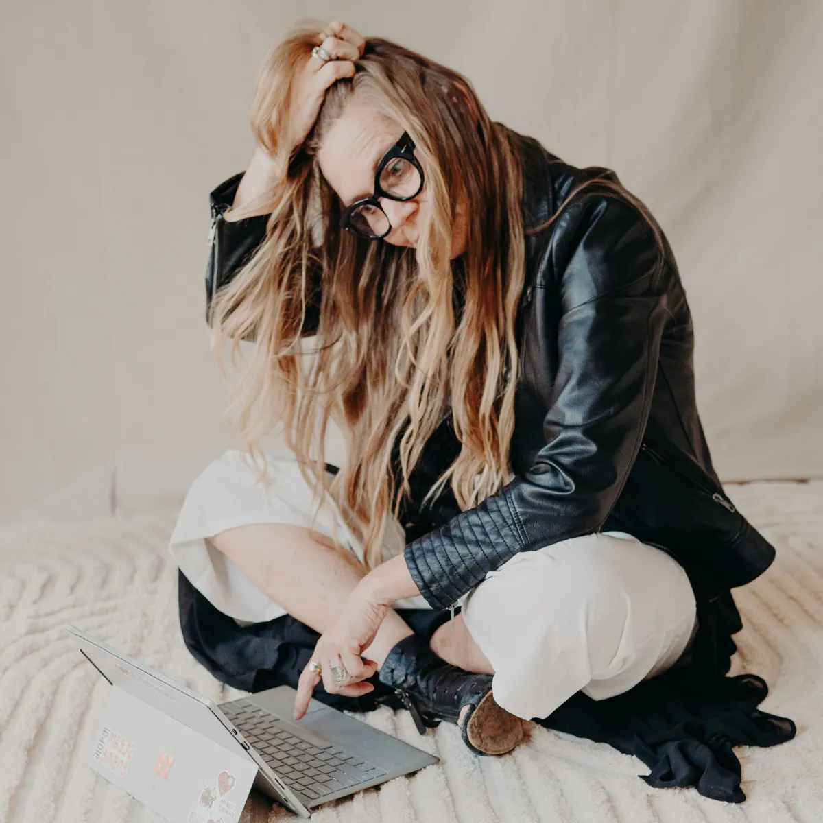Woman sitting on floor with computer. Looking disconnected.