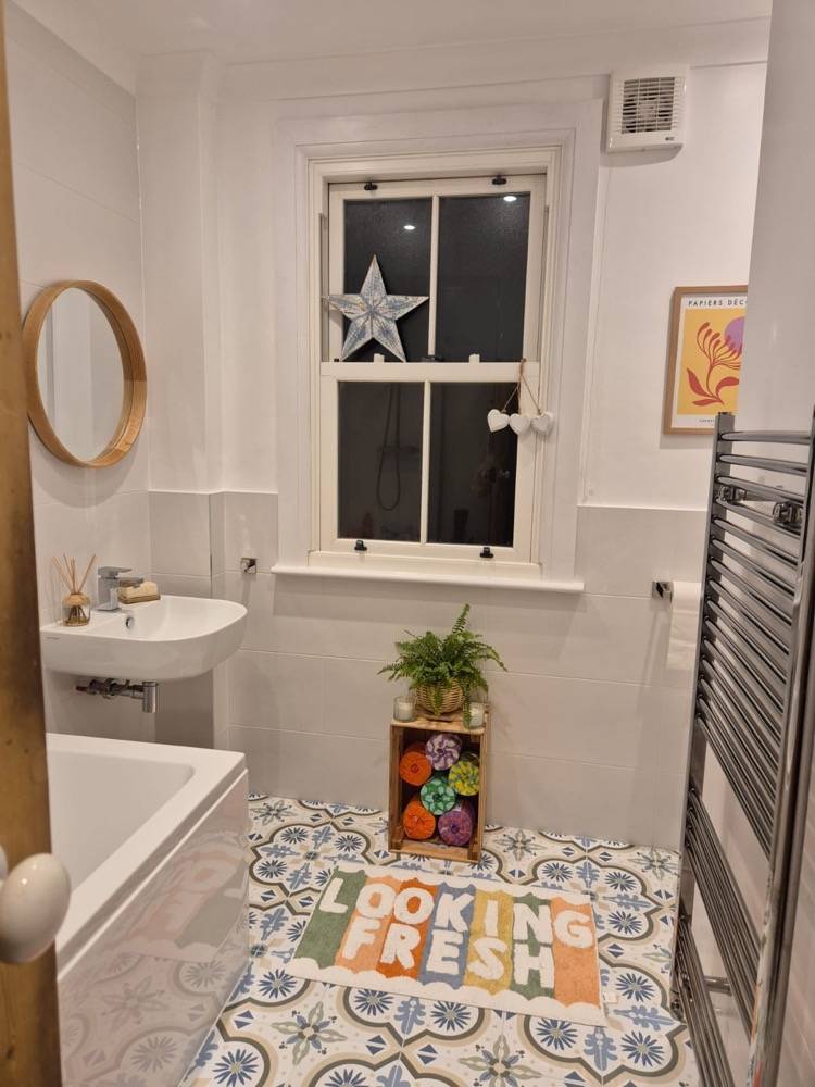 Bright white bathroom with sash window, vanity sink and heated towel rail
