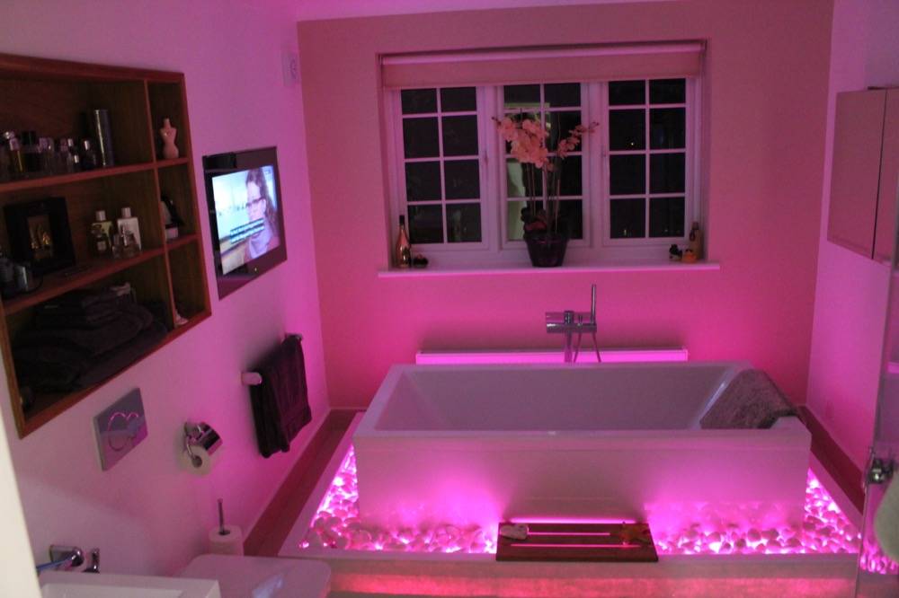 Bathroom with panelled bath, colour-changing LED lighting and wall-mounted TV in Chorleywood