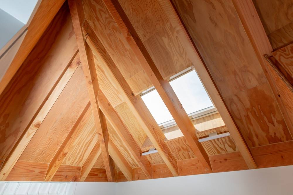 Exposed timber roof rafters with Velux skylights in new build family home