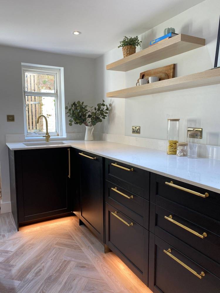 Kitchen with dark units, brass handles and marble worktops in Hemel Hempstead
