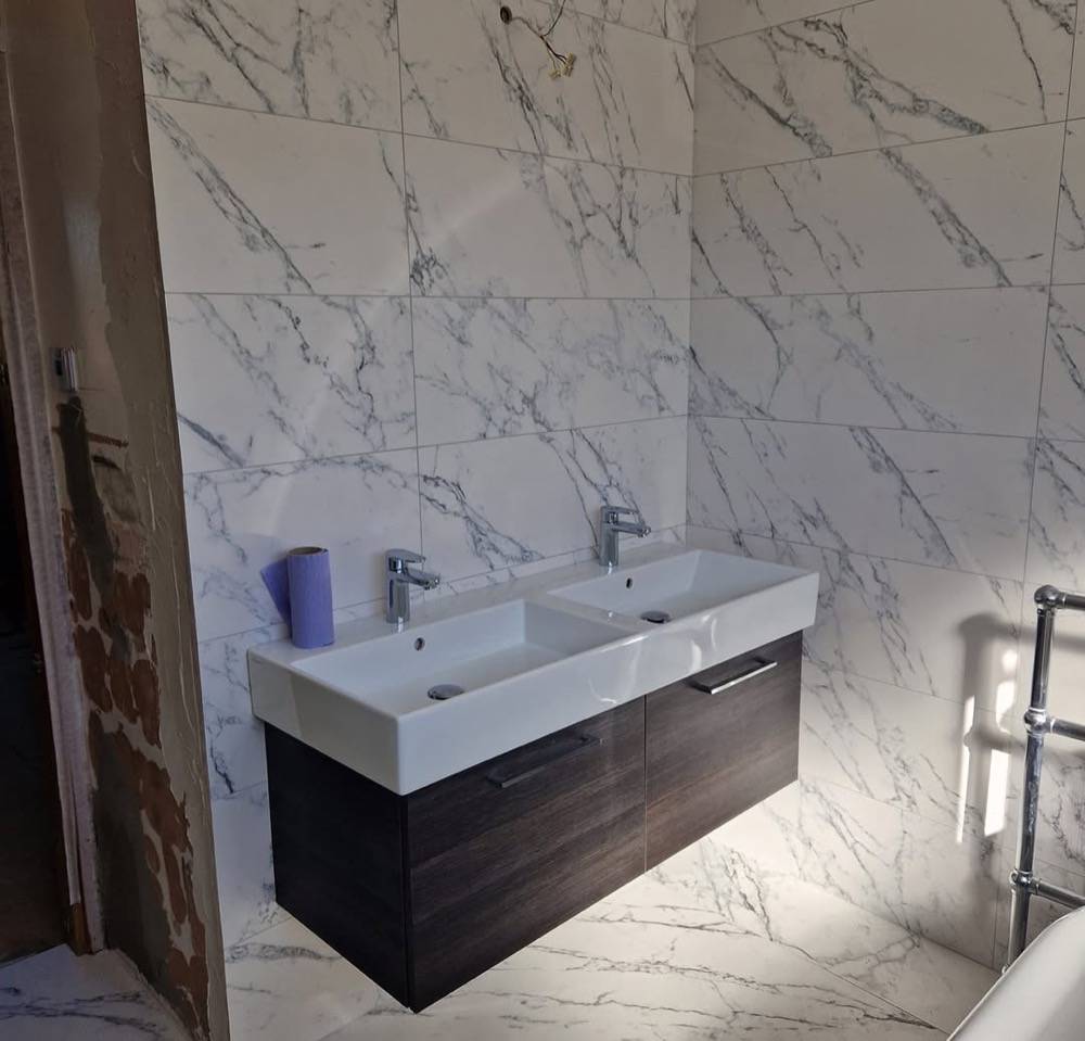 Marble bathroom with double wash basin on dark vanity unit