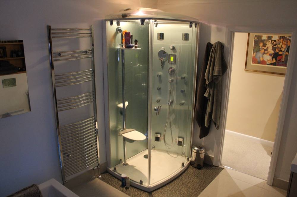 Bathroom with self-contained steam shower cabin and heated towel rail in Chorleywood