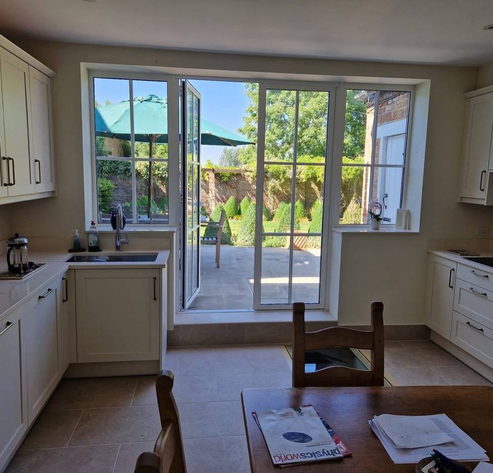Refurbished kitchen with French doors opening to garden by DR Construction