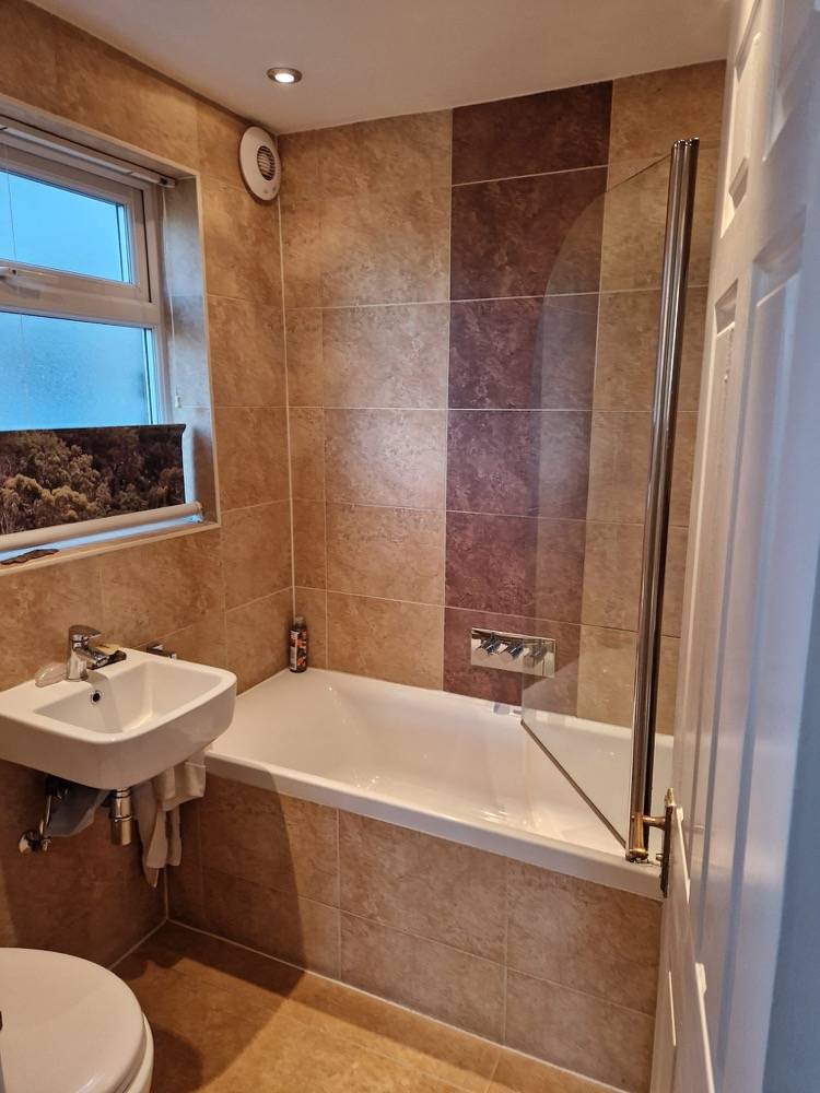 Traditional beige and brown tiled bathroom with bath and pedestal basin