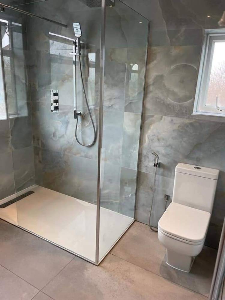 Grey marble-effect wet room with walk-in shower and glass screen by DR Construction