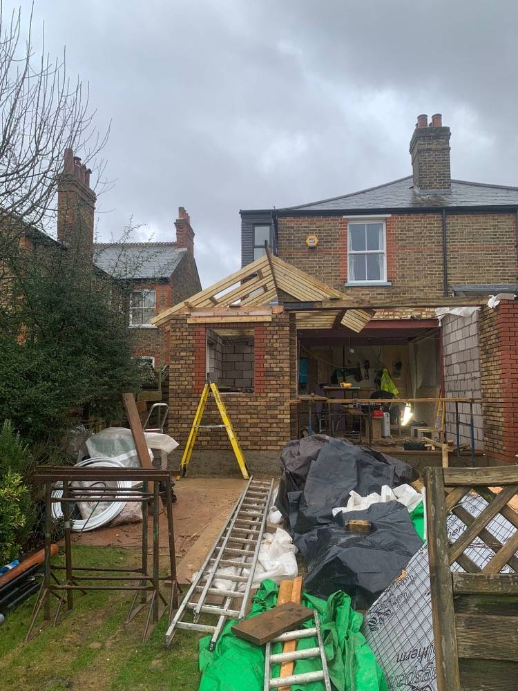 Rear extension mid-build with timber roof structure and brick walls by DR Construction