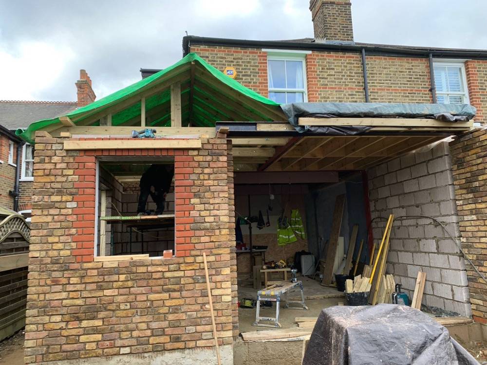 Extension under construction with green roofing felt being laid