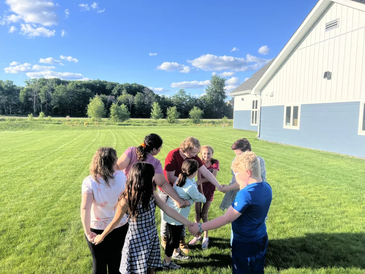 Kids praying in a circle at Chain of Lakes Church