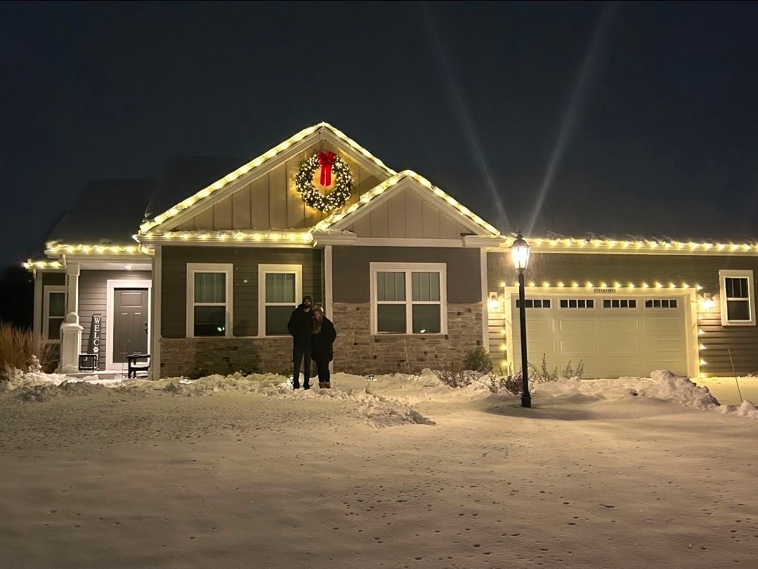 House with professional holiday lighting installation at night