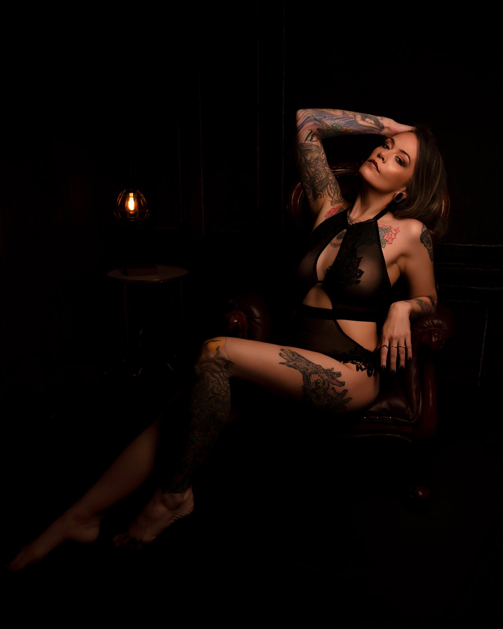 Woman seated on chair in boudoir studio setting