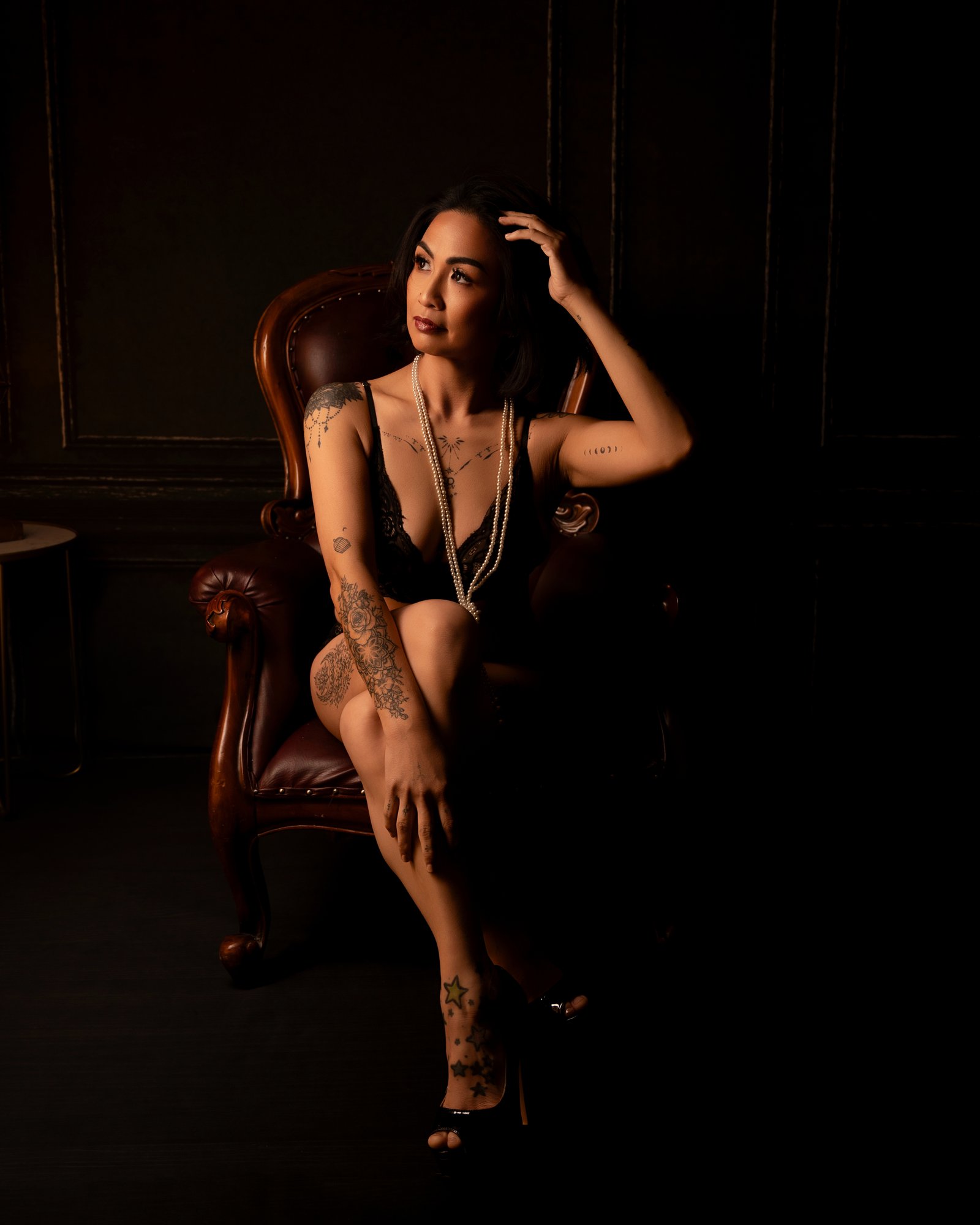 Woman posing on velvet chair during boudoir session