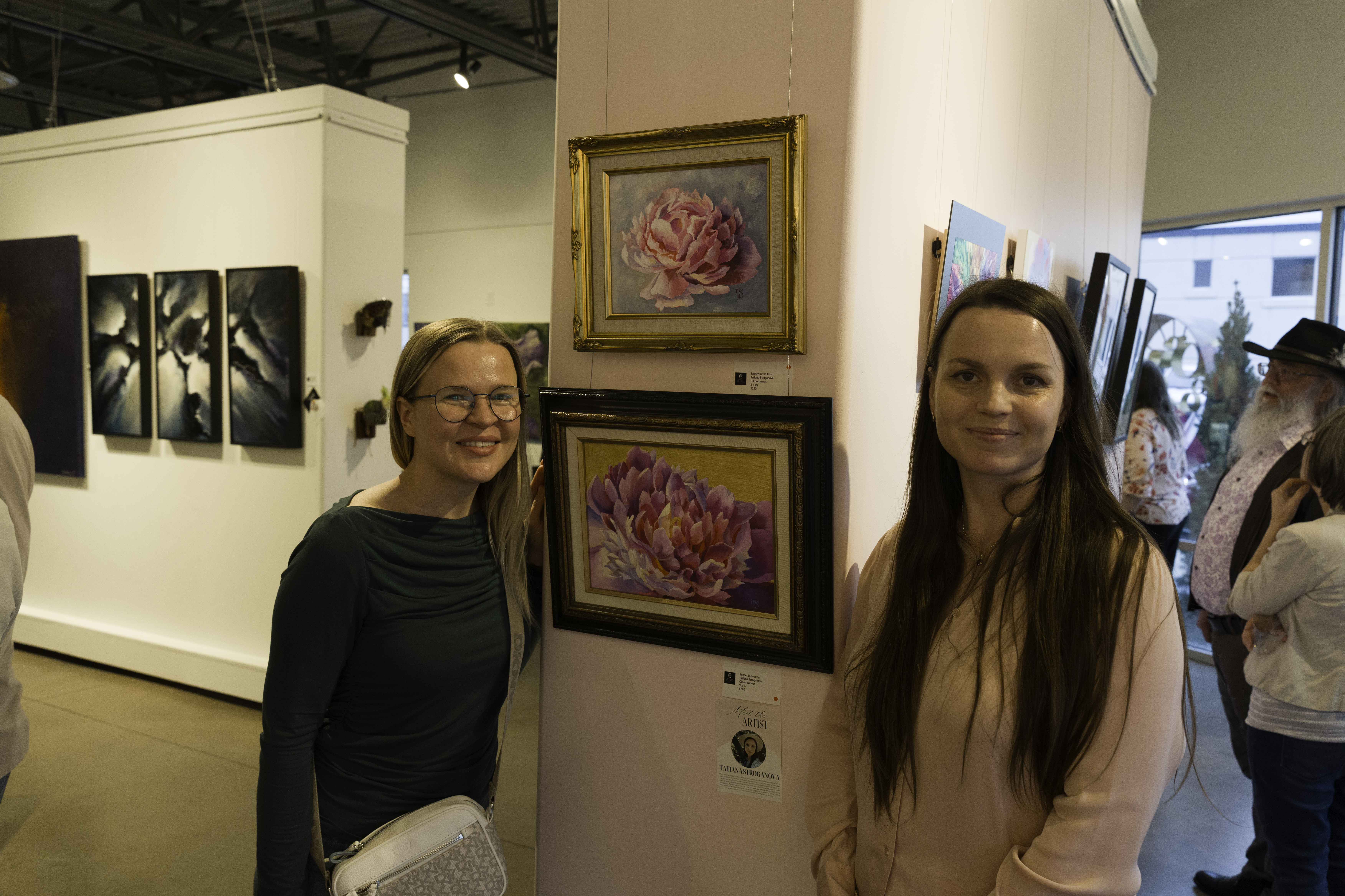 artist and buyer viewing floral artwork inside Create Gallery and Frames, a fine art gallery in Garden City, Idaho
