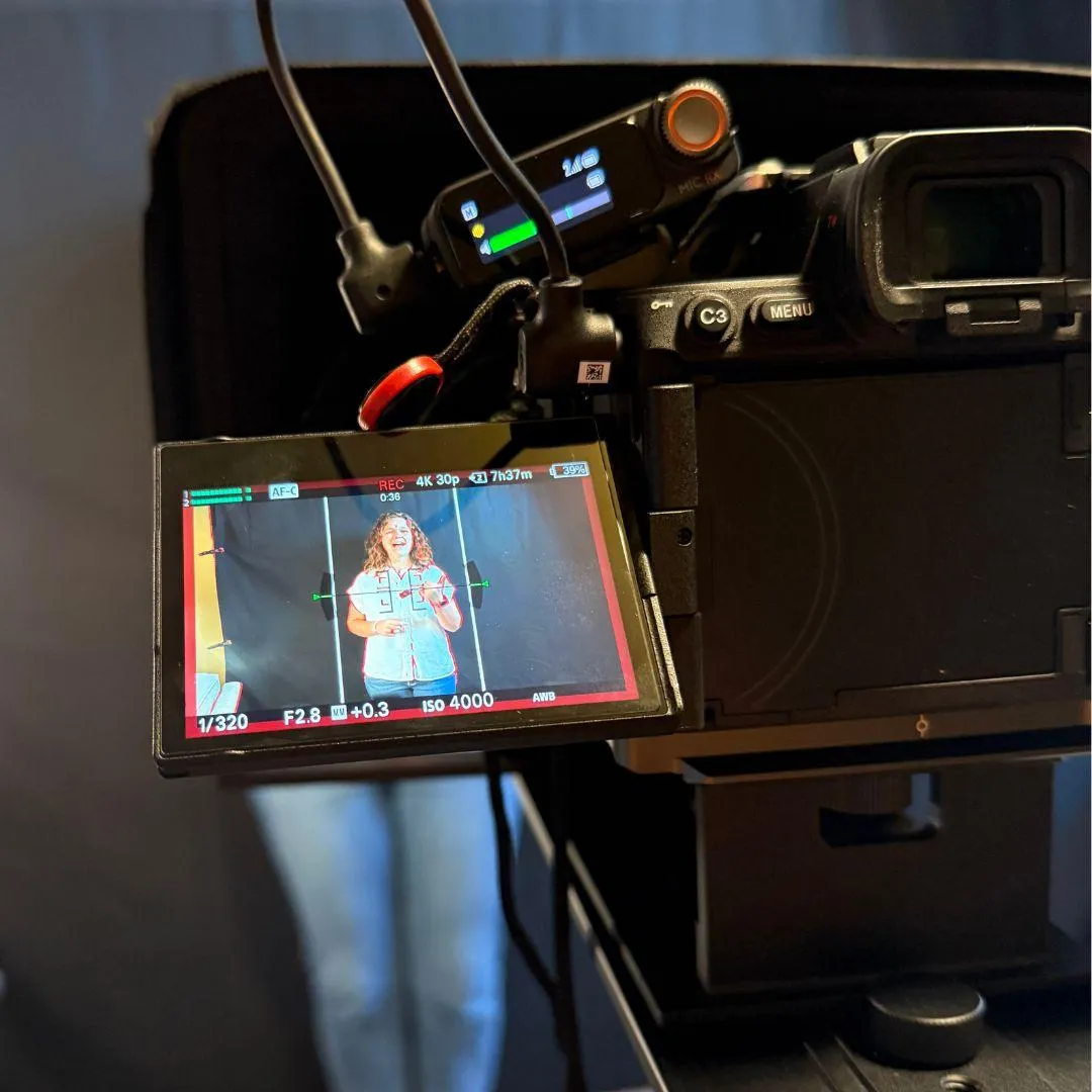 Woman standing in front of a Camera.