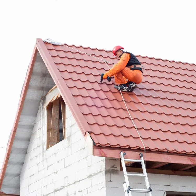 Worker On A Red Tile Roof