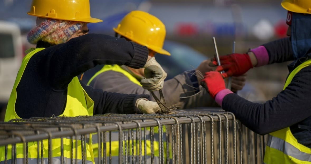 a wooden walkway leading to a building with glass doors