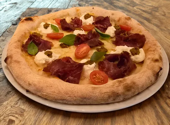 several sliced of vegetable pizza on round white platter