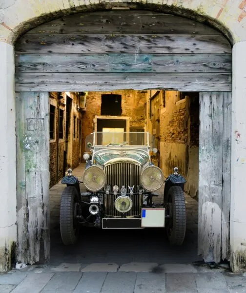 Sir San's Elite Selfer, like a 1920s Model T, sitting in the open doorway of a barn