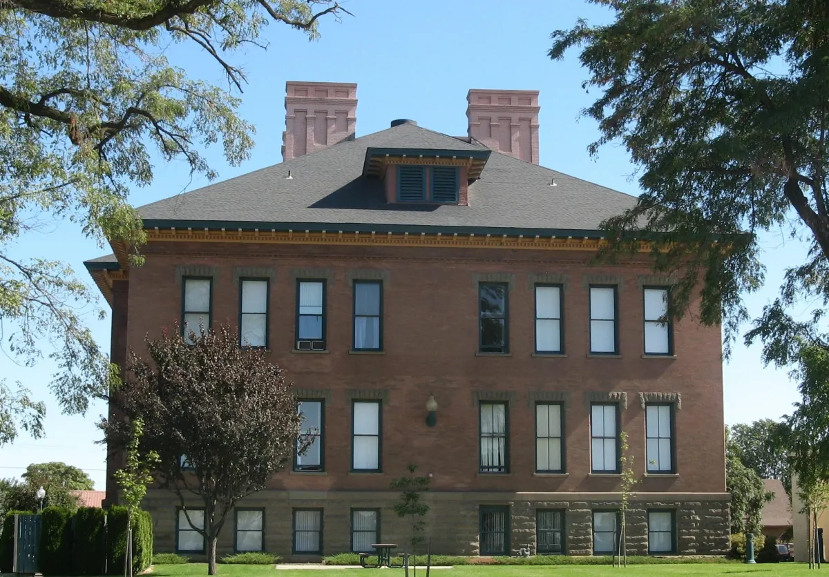 Bridgeton School -- brick building rising three stories with numerous narrow windows with trees beckoning from without