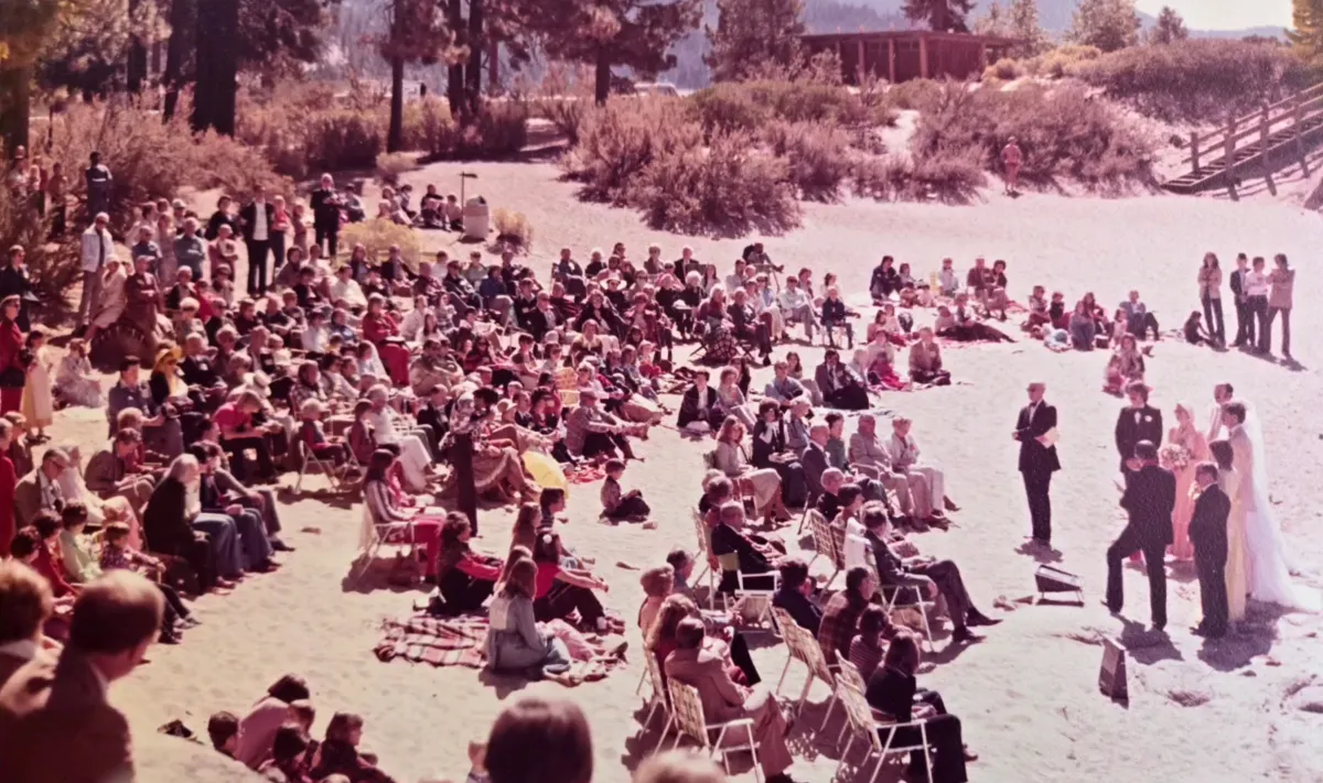 A crowd gathered in wedding attire sitting in sun chairs to bear witness to the wedding at Sand Harbor State Park, Lake Tahoe