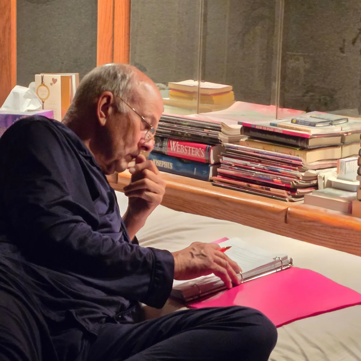 C. S. Fitzpatrick's husband reclining and perusing her manuscript with a hand held thoughtfully to his mouth and the other poised with a pencil at the ready