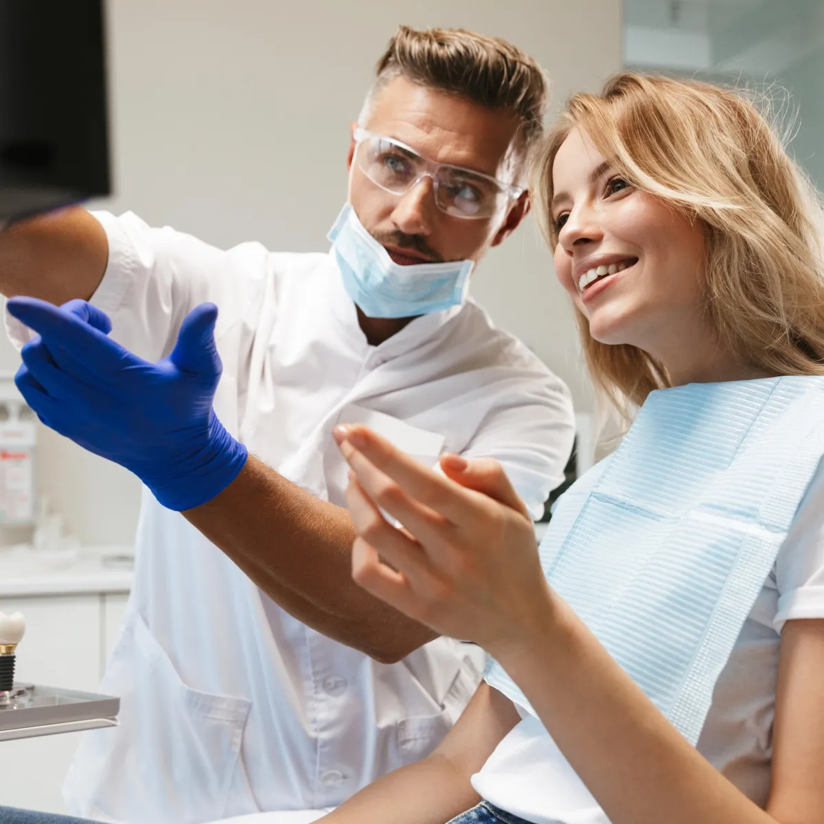 Dentist pointing and showing patient information on monitor