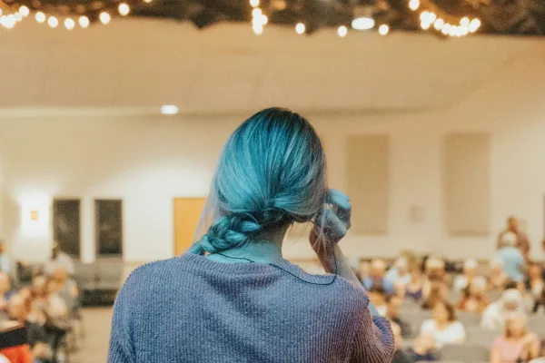 back of head of a woman nervously speaking to an audience 