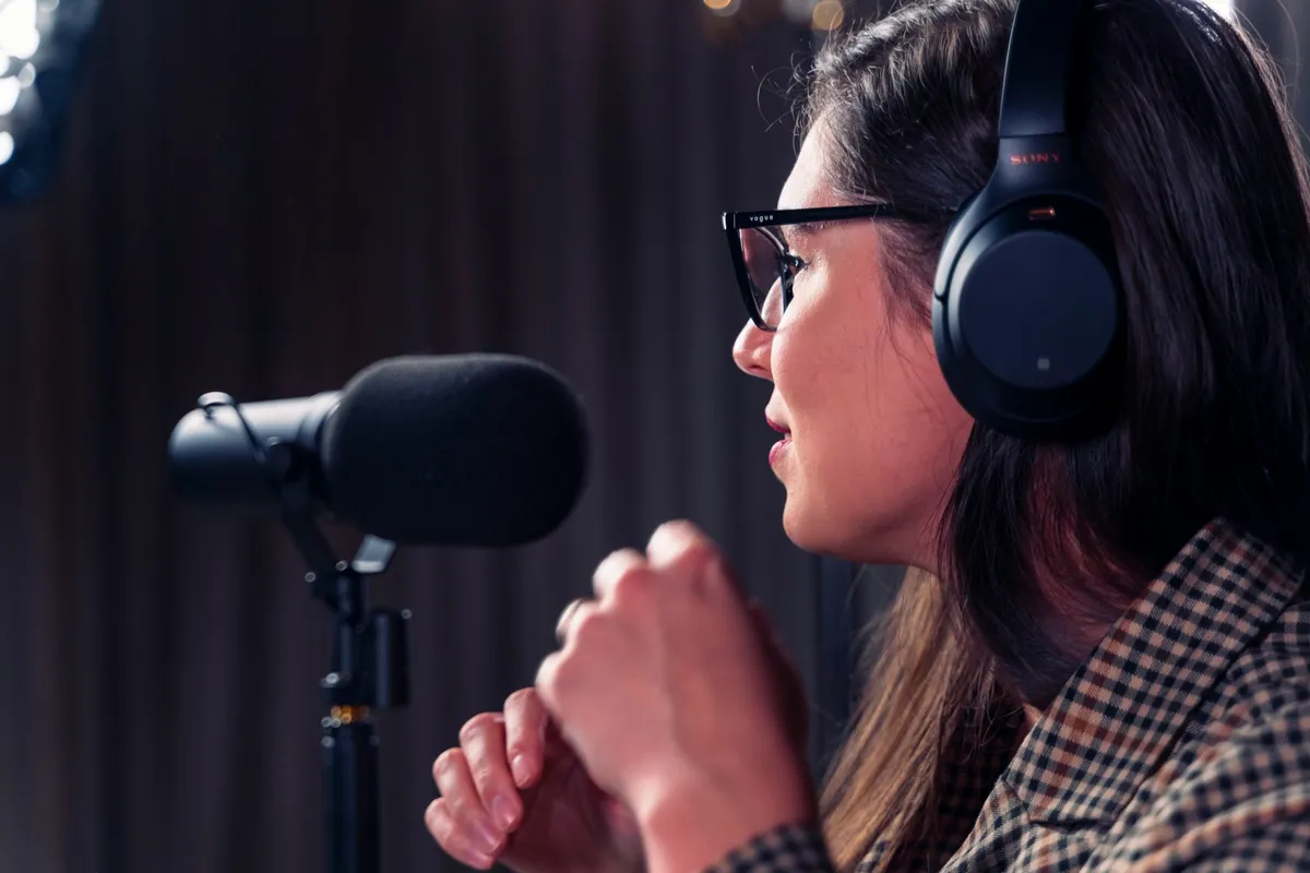 Woman speaking to a microphone with headphones on 
