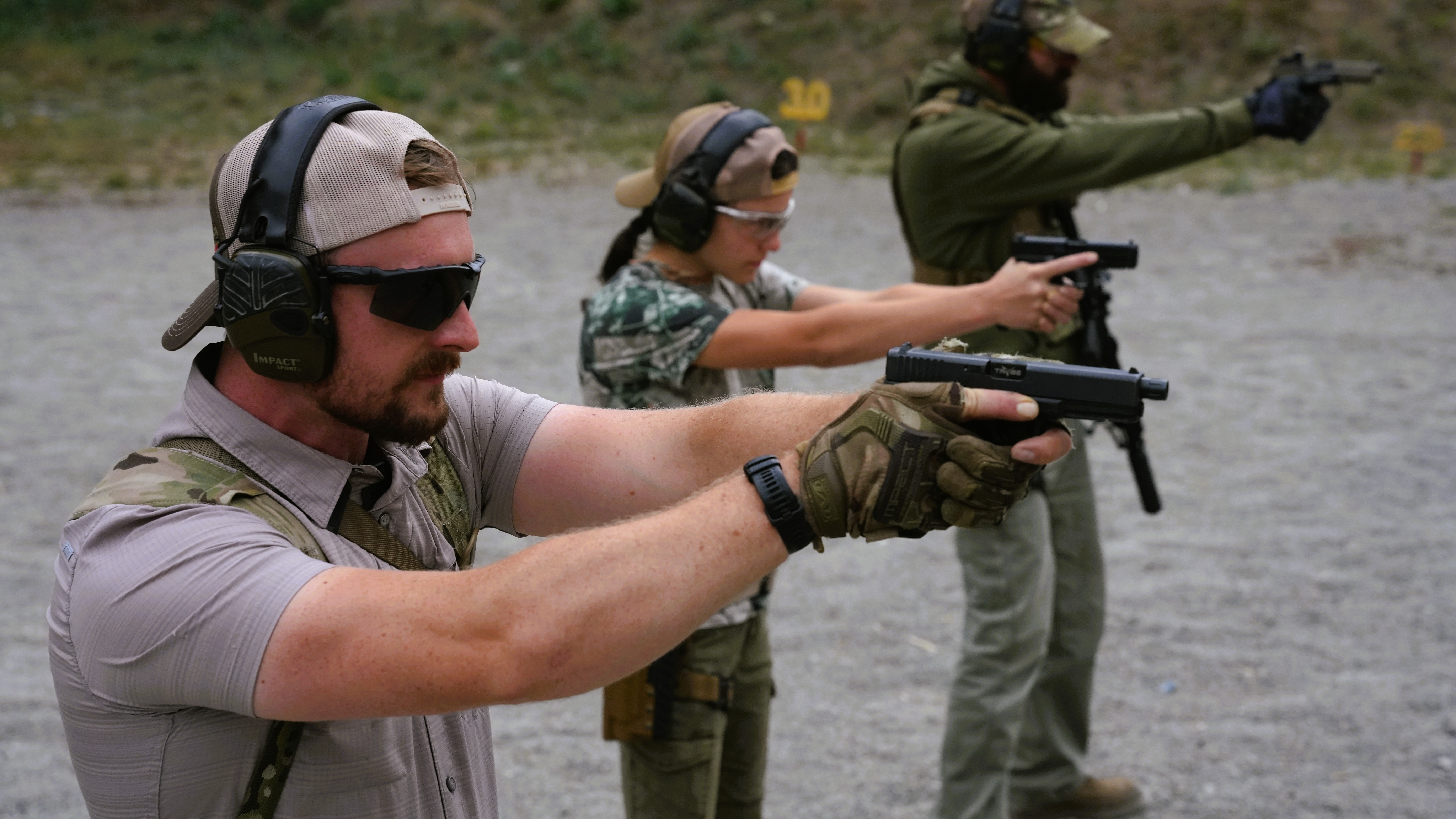 Two trainees practicing a fast striking drill on a dark range mat