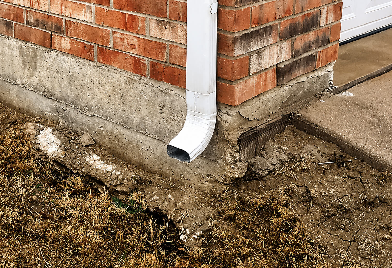 Eroded brick corner and downspout