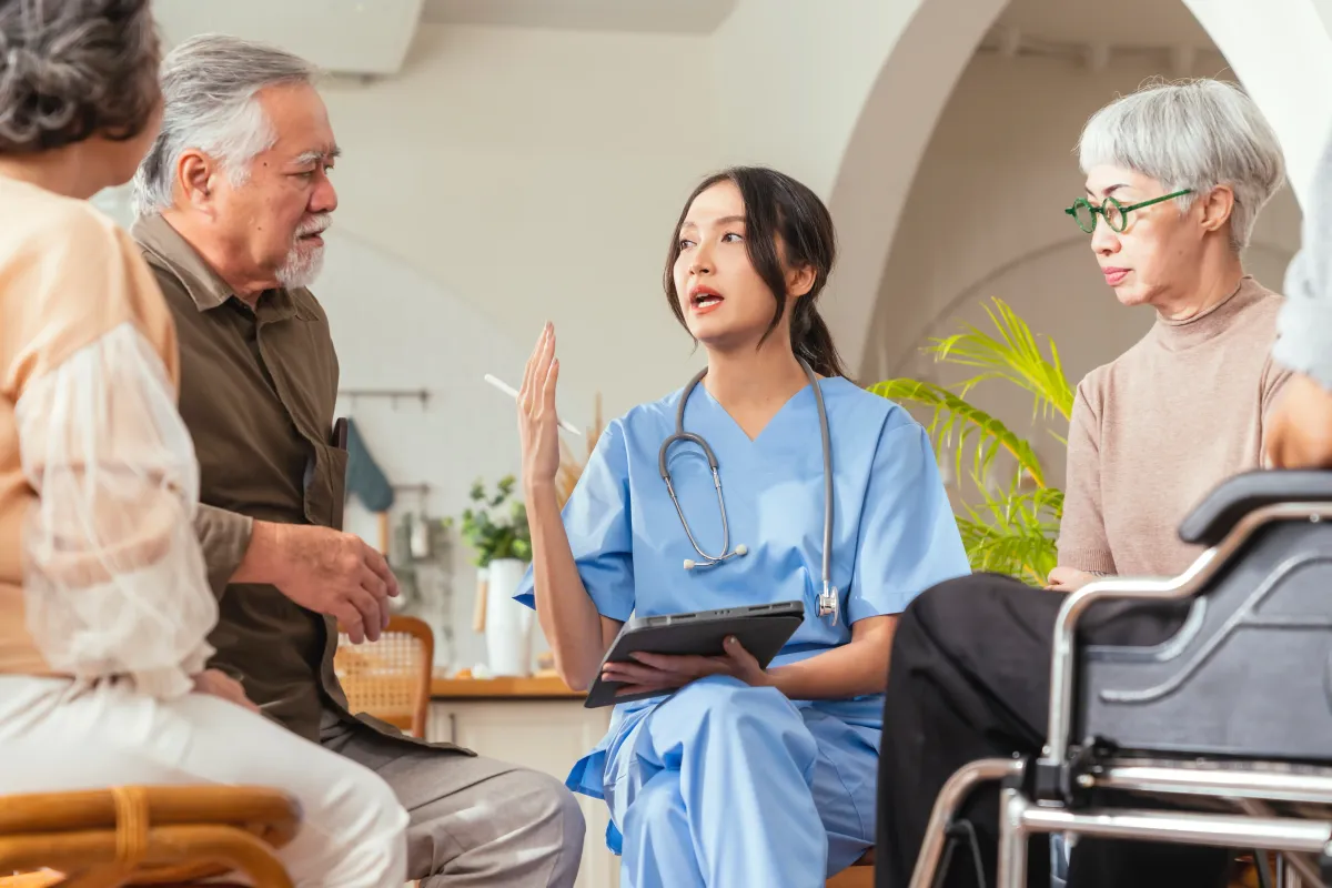 woman talking to seniors in assisted living facility