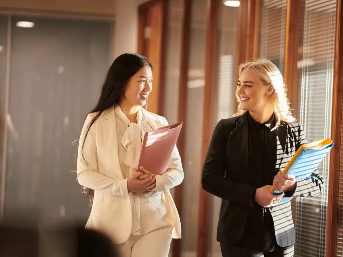 Two businesswomen walking an smiling